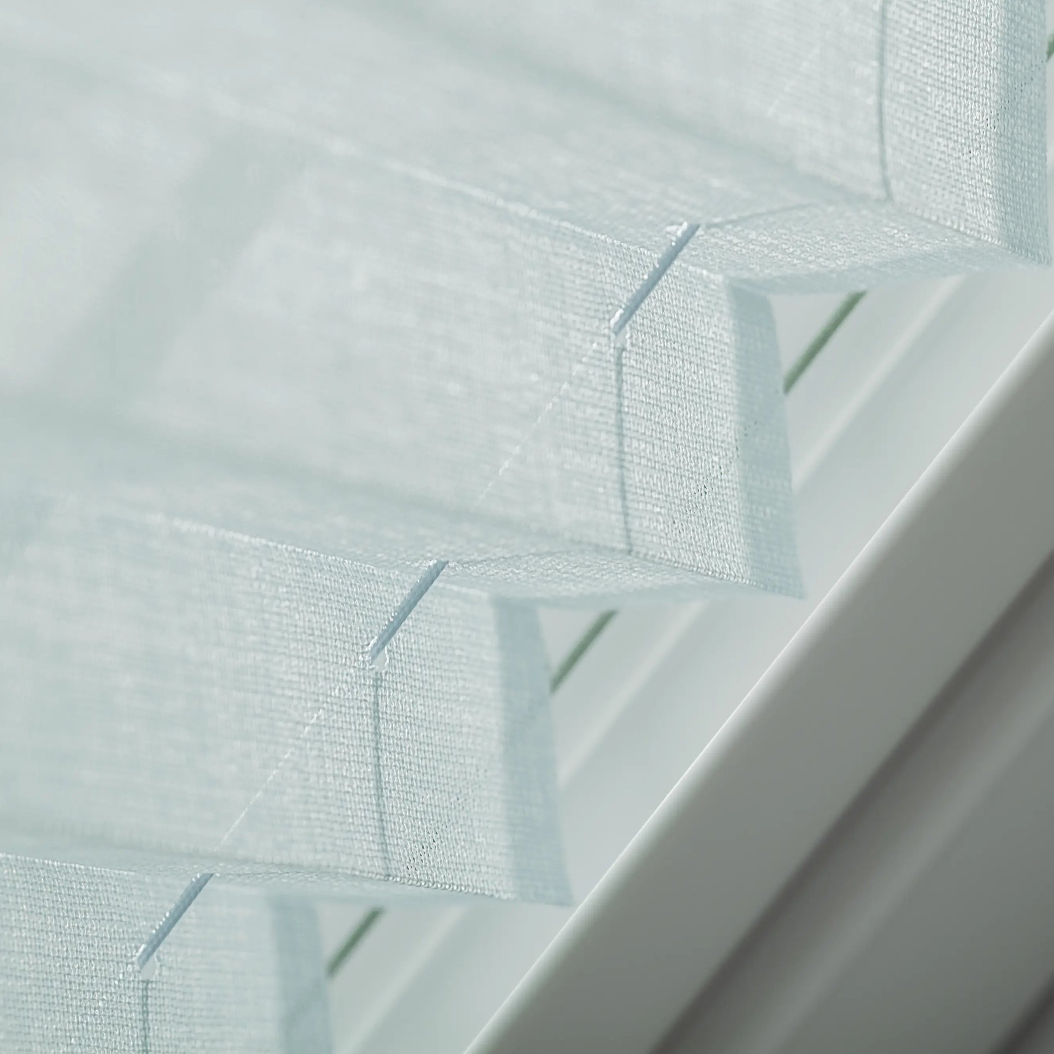 Close-up of window blinds with fabric texture and slats alignment.