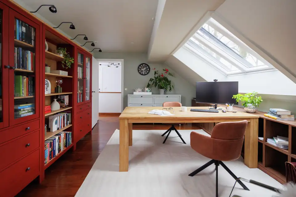 Bibliothèque et bureau dans un comble aménagé avec fenêtres de toit VELUX. 