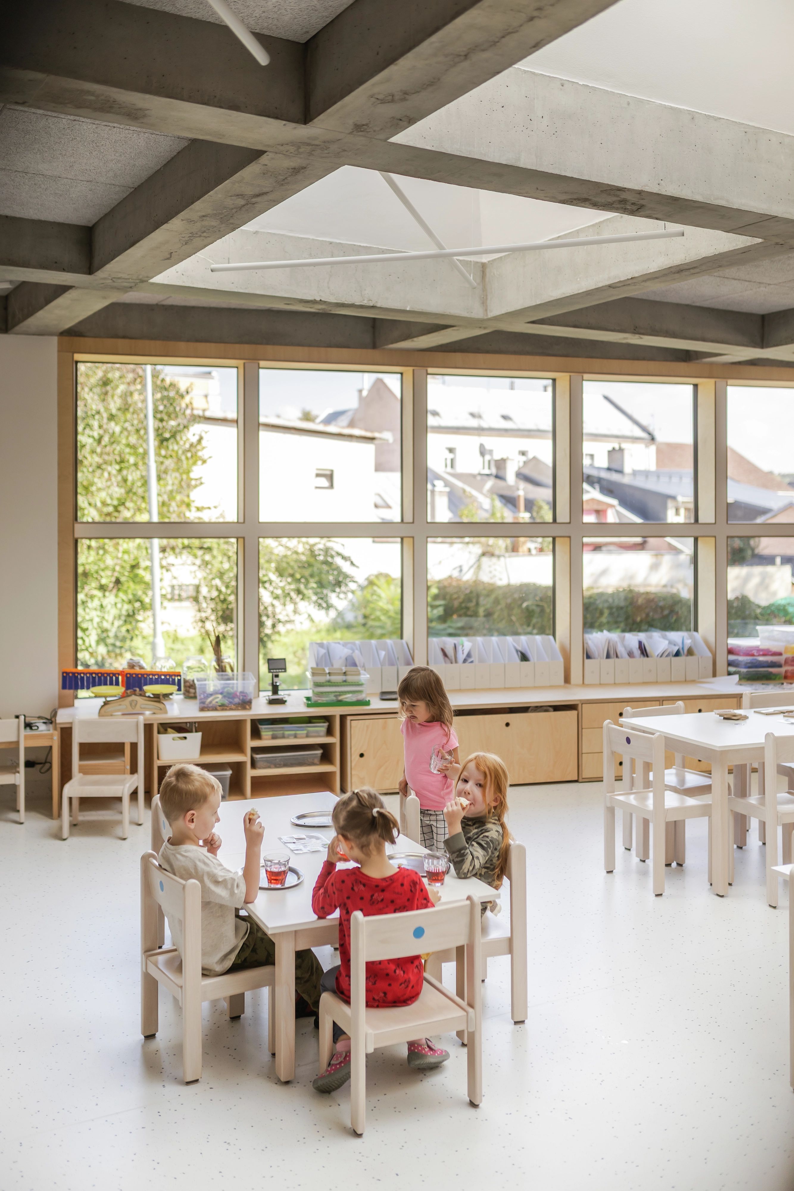 Daycare room with large windows and children's furniture.