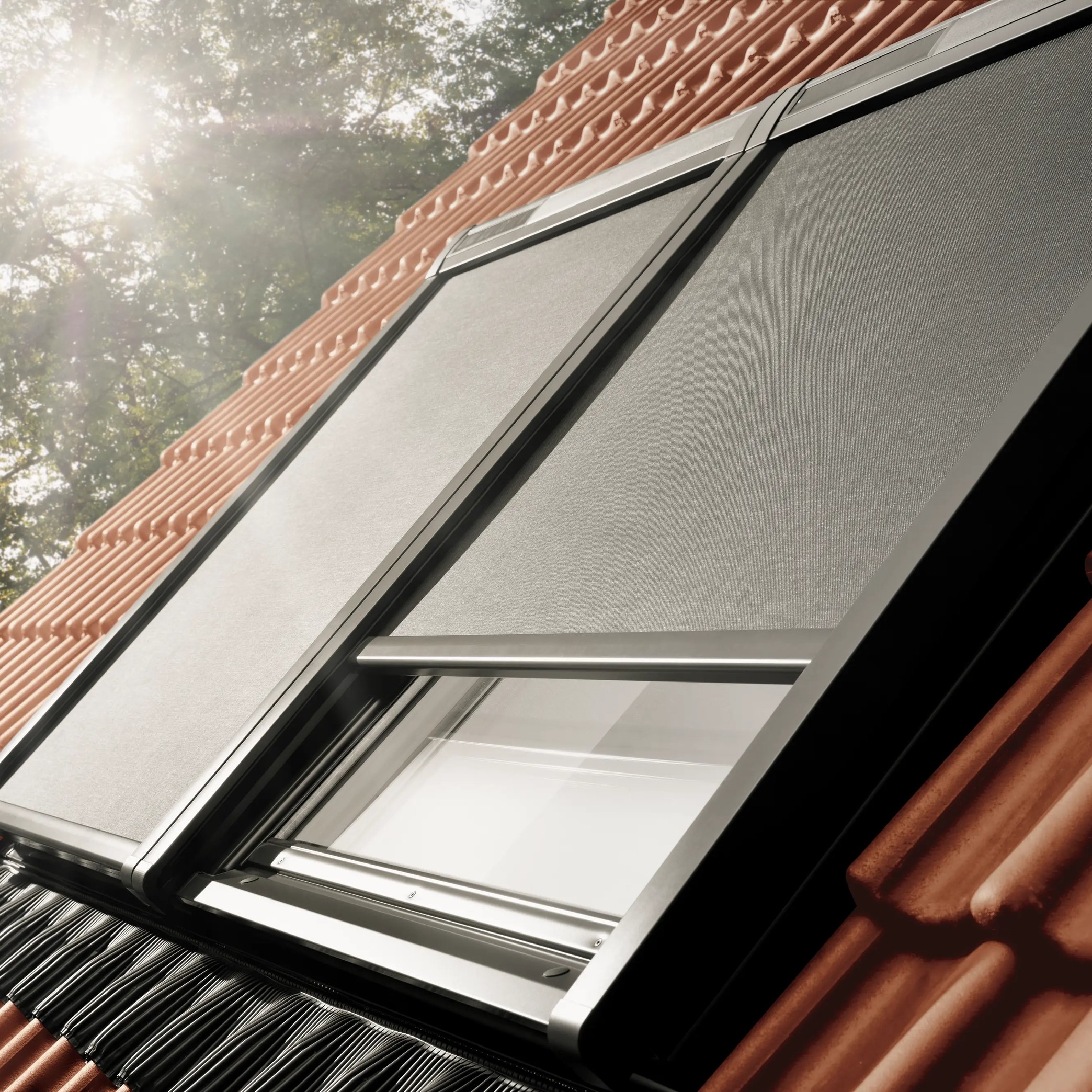 VELUX roof window on a red tiled roof with awning blinds.