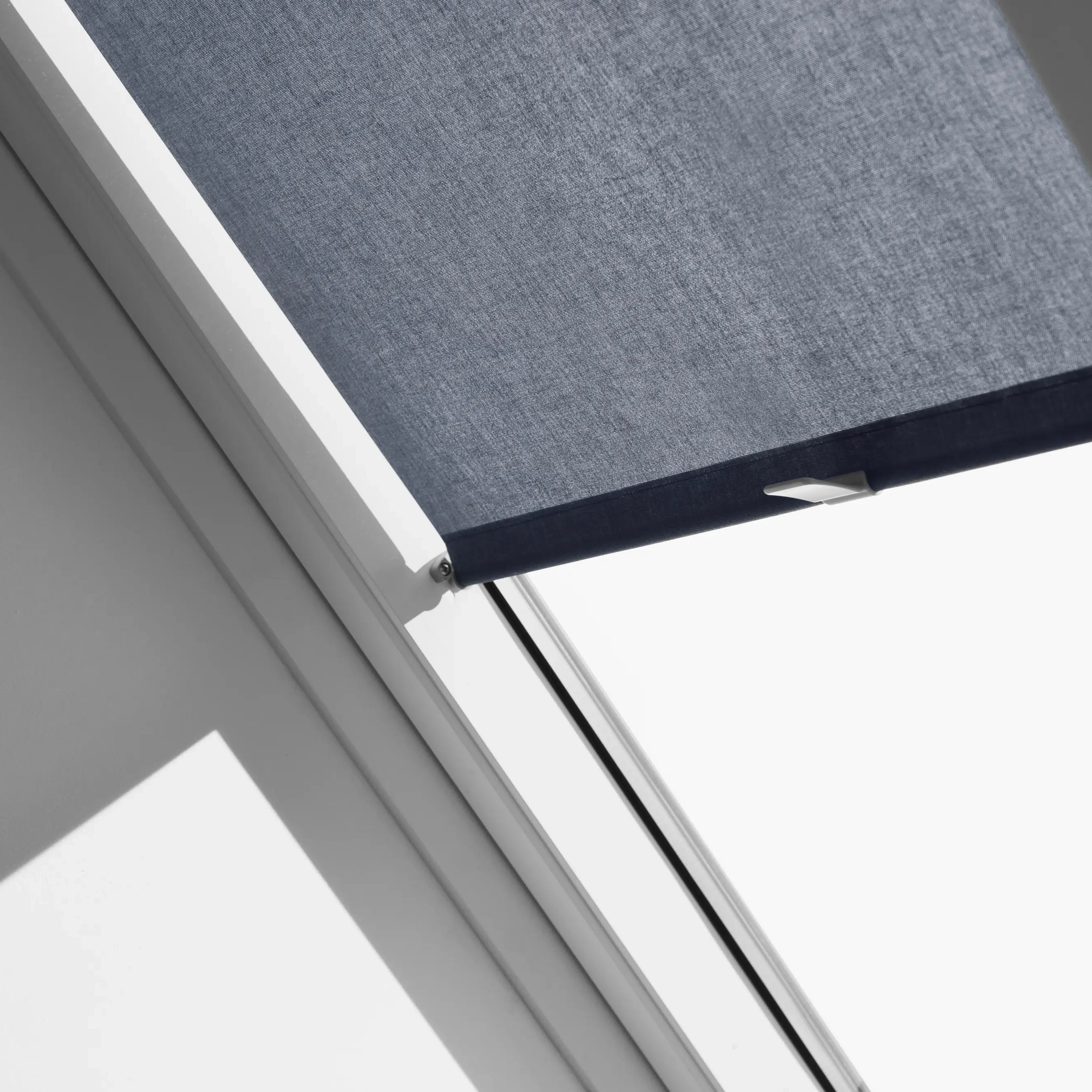 VELUX roof window with dark fabric blind, high ceiling position.