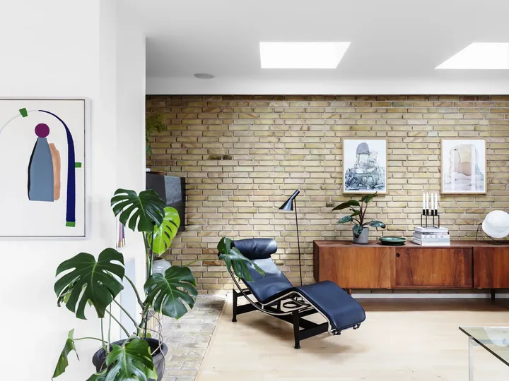 Zwei Oberlichter fluten Wohnzimmer mit Designermöbeln und Backsteinwand mit Tageslicht