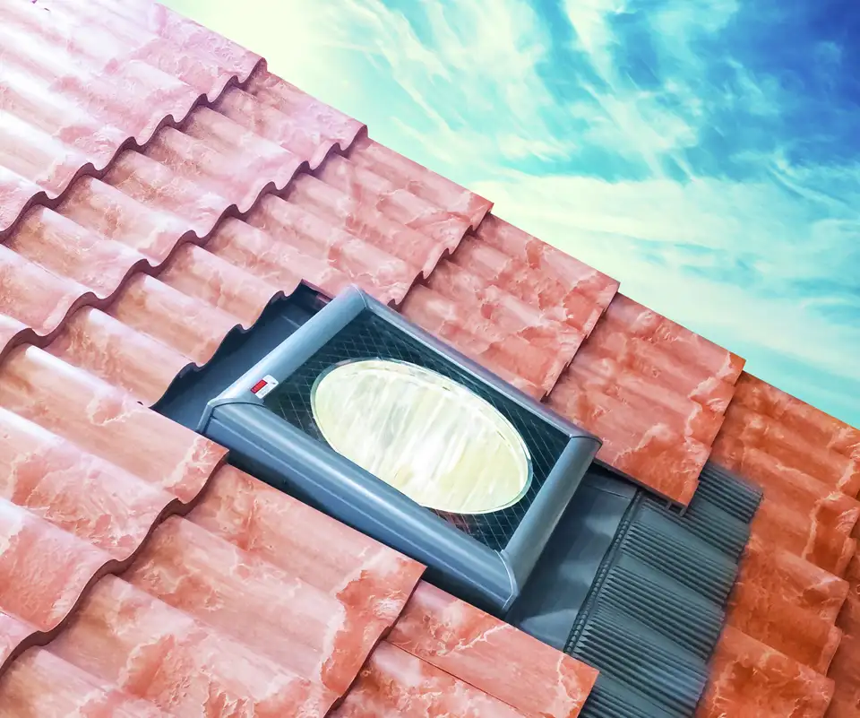 Lichttunnel op een pannendak met een koepelvormige lichtvanger aan de oppervlakte 