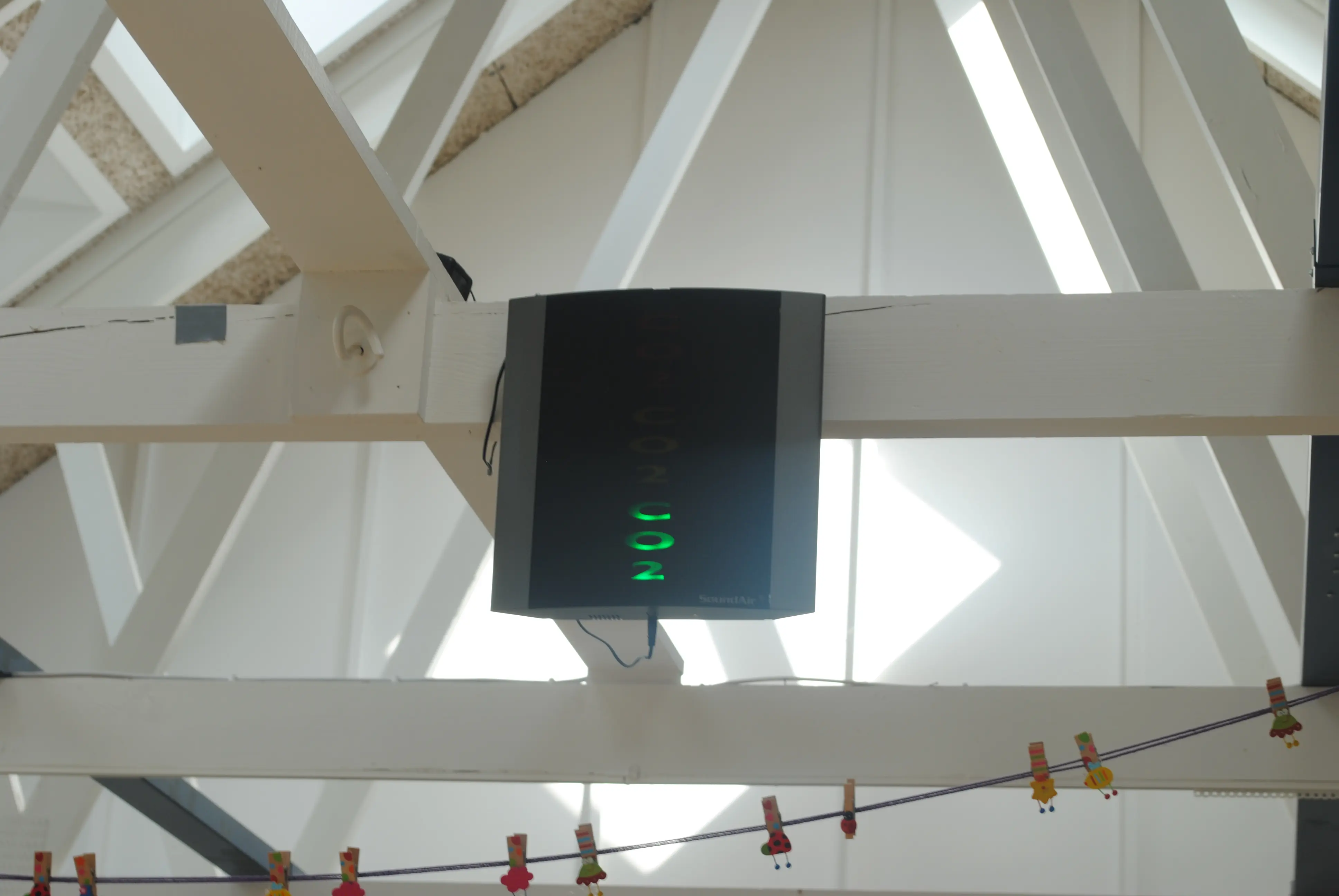 Potkrovlje s vidljivim gredama i CO2 monitorom, vidljivi VELUX krovni prozori