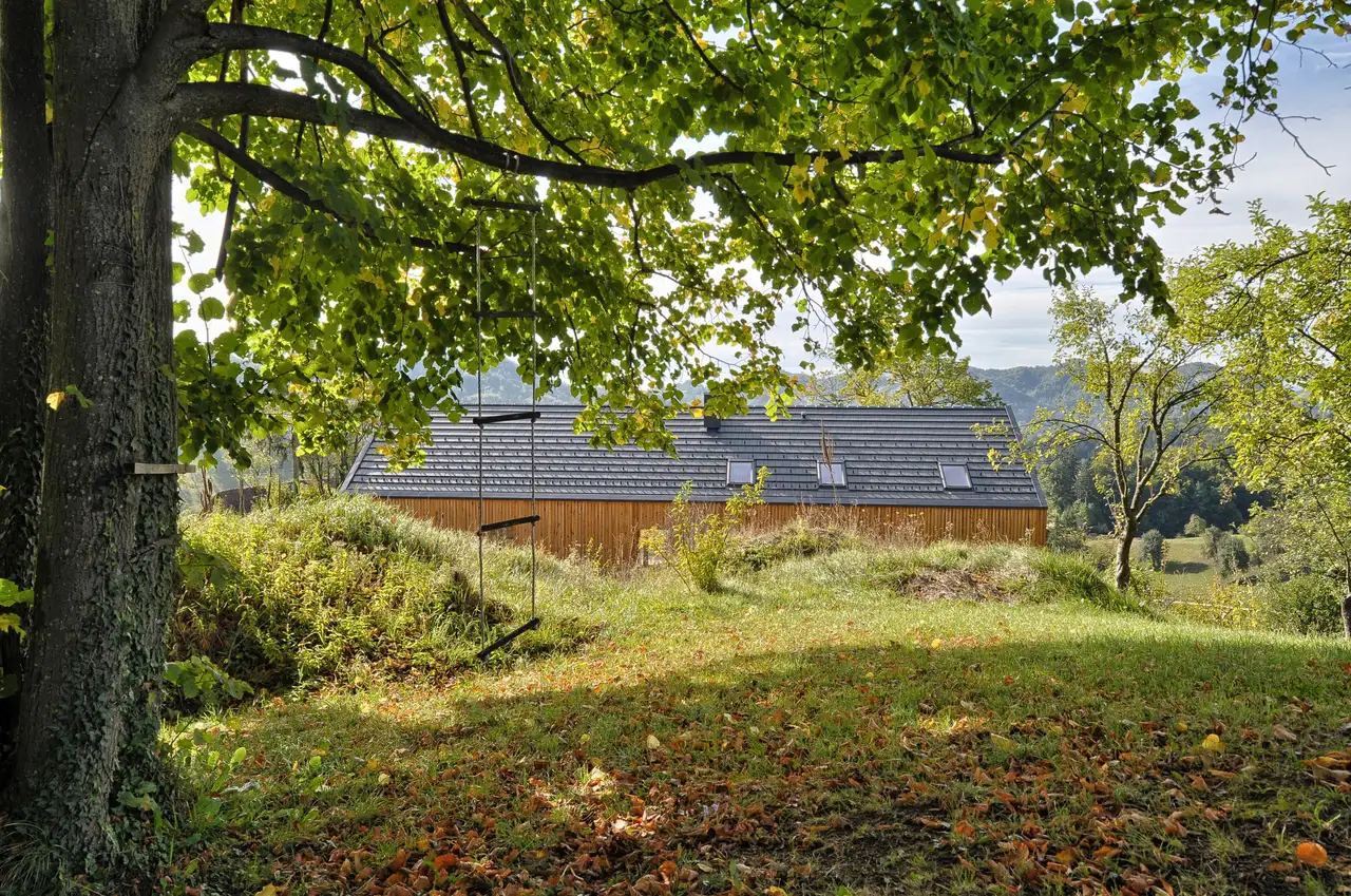 maison de campagne entourée de verdure, avec toit à deux pans et fenêtres de toit VELUX