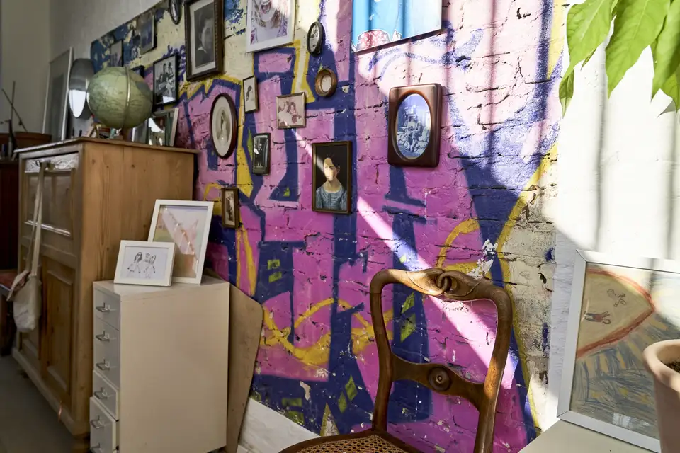 Mur décoré de cadres et objets vintage dans un intérieur coloré et chaleureux