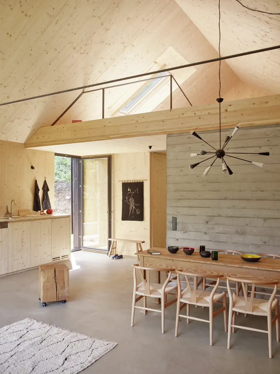 Sala da pranzo con soppalco con finestra per tetti VELUX, arredamento in legno.