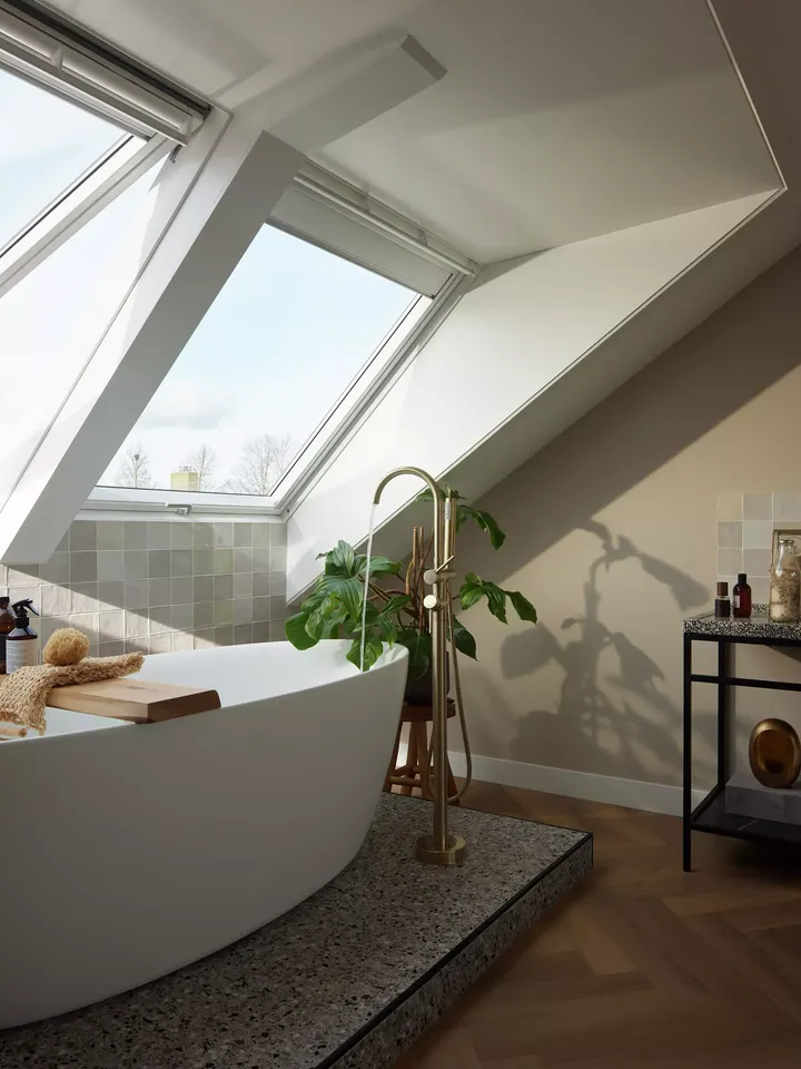 Modernes Badezimmer im Dachboden mit VELUX Dachflächenfenstern und freistehender Badewanne.