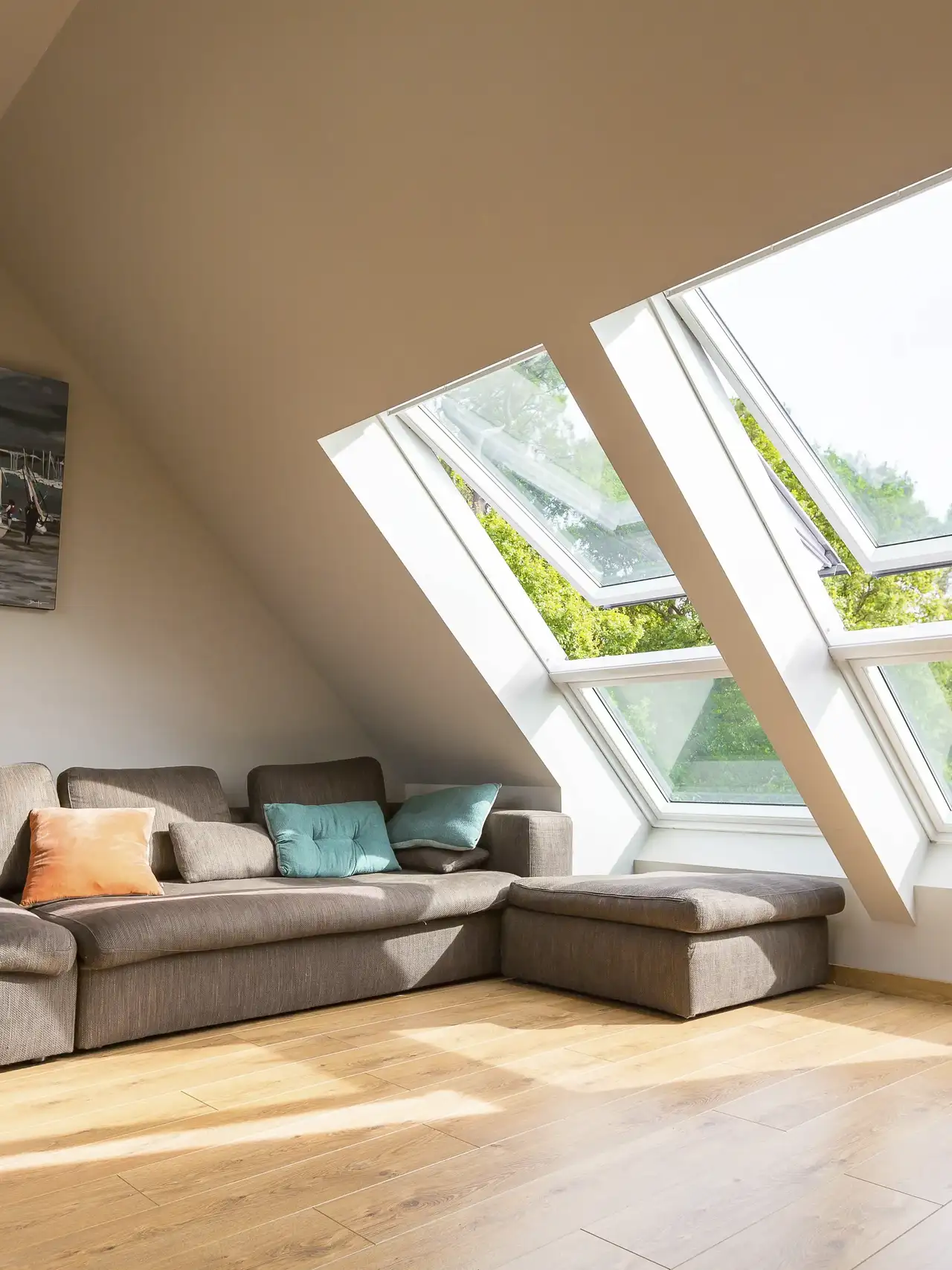 Salon sous les toits avec larges fenêtres de toit VELUX