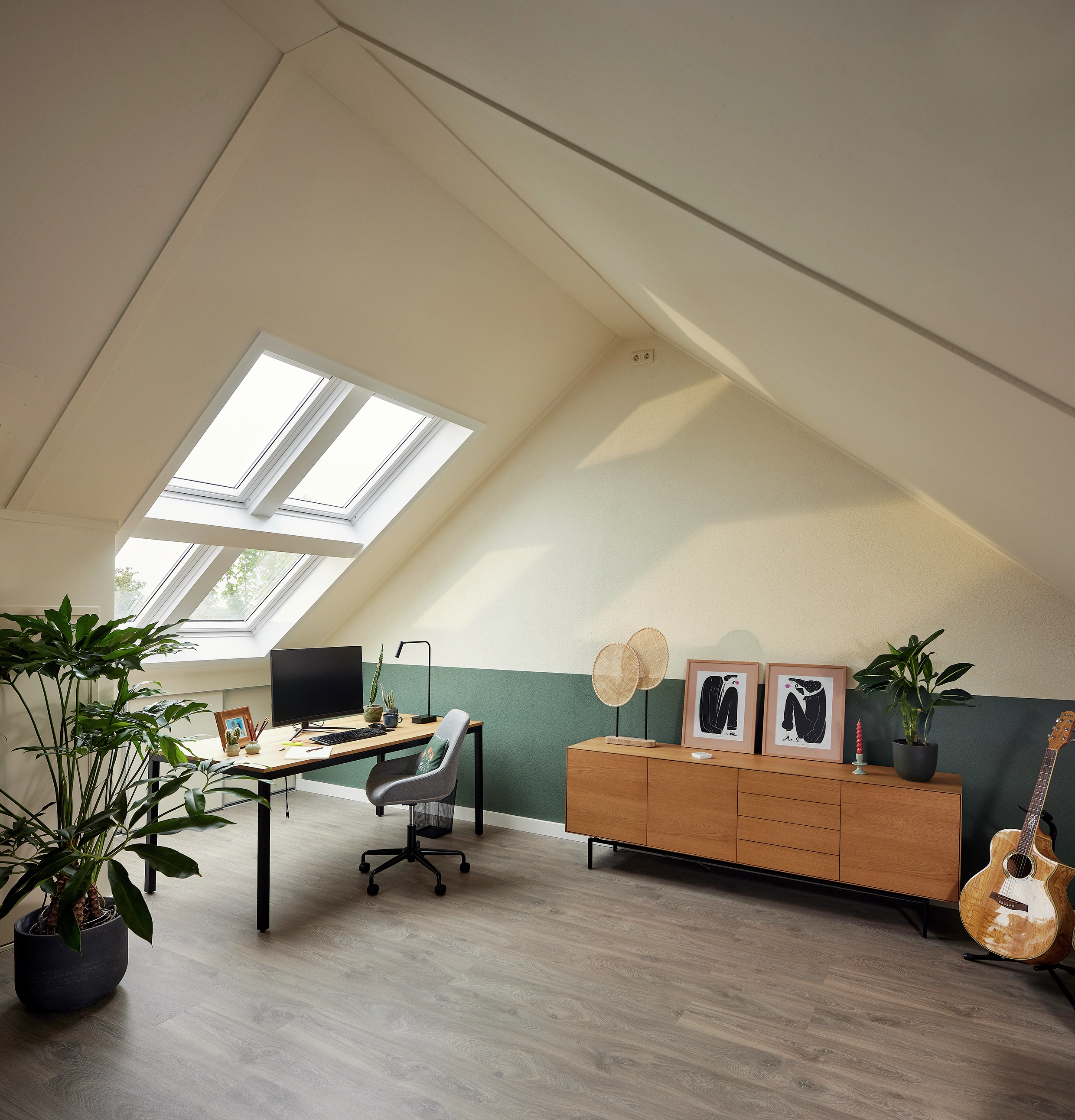 Lichtrijke zolder thuiskantoor met een Quattro VELUX dakraamcombinatie en licht houten meubelen.