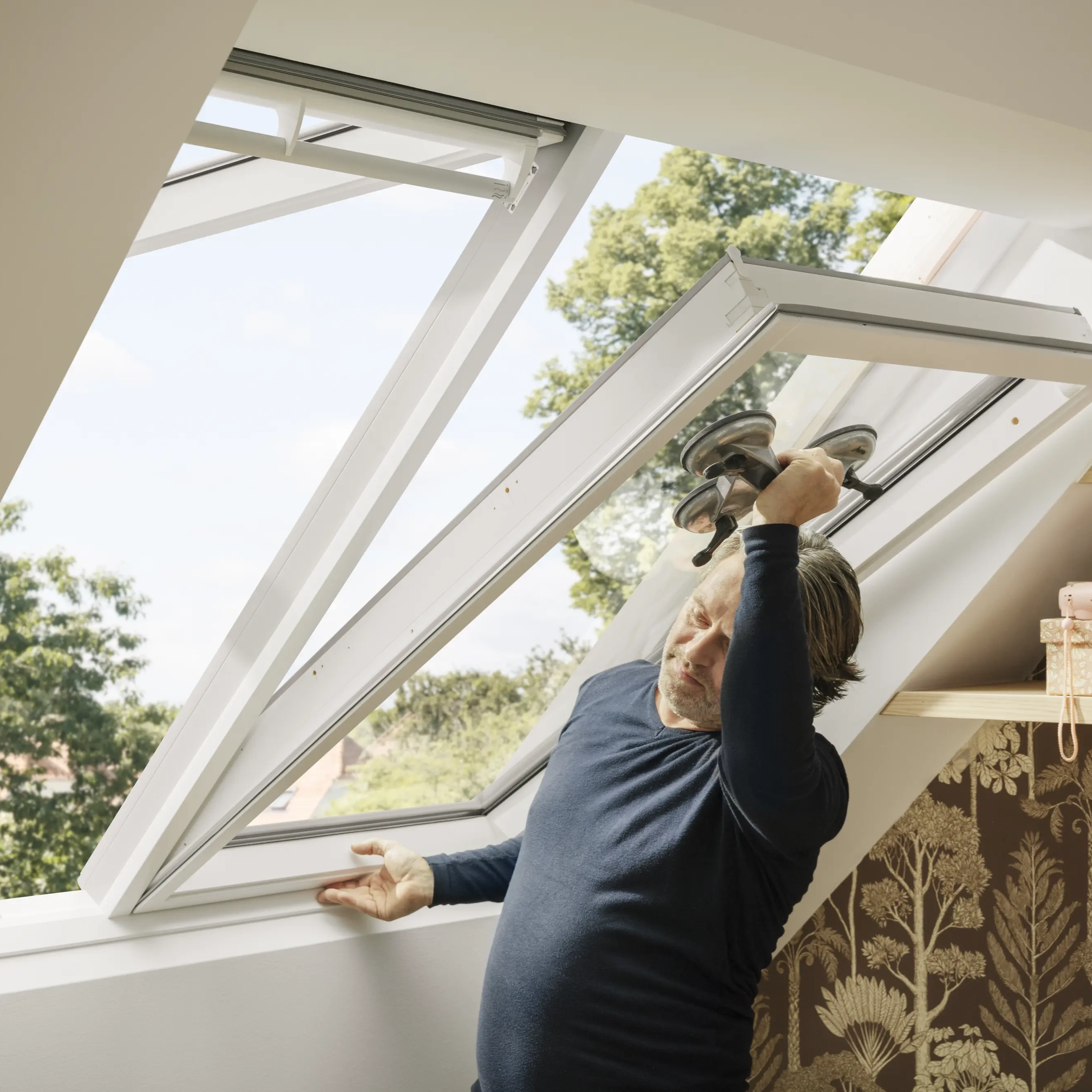 Hombre desmontando una ventana de tejado 