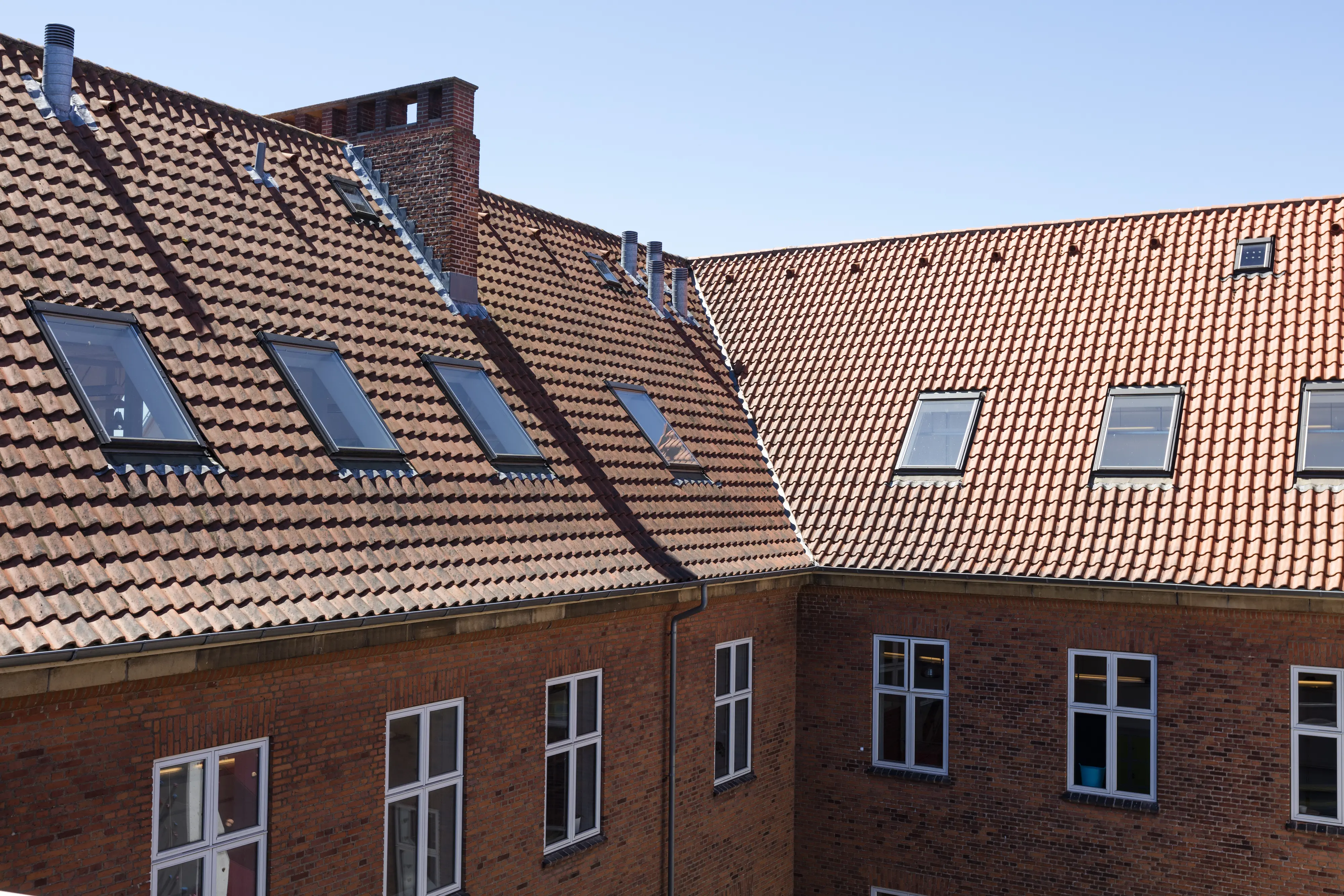 Zgrada od opeke sa strmim krovom i VELUX potkrovnim prozorima.