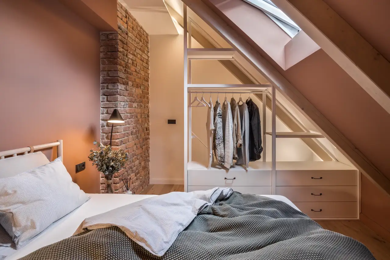 Camera da letto con finestre per tetti delimitata da un guardaroba a giorno
