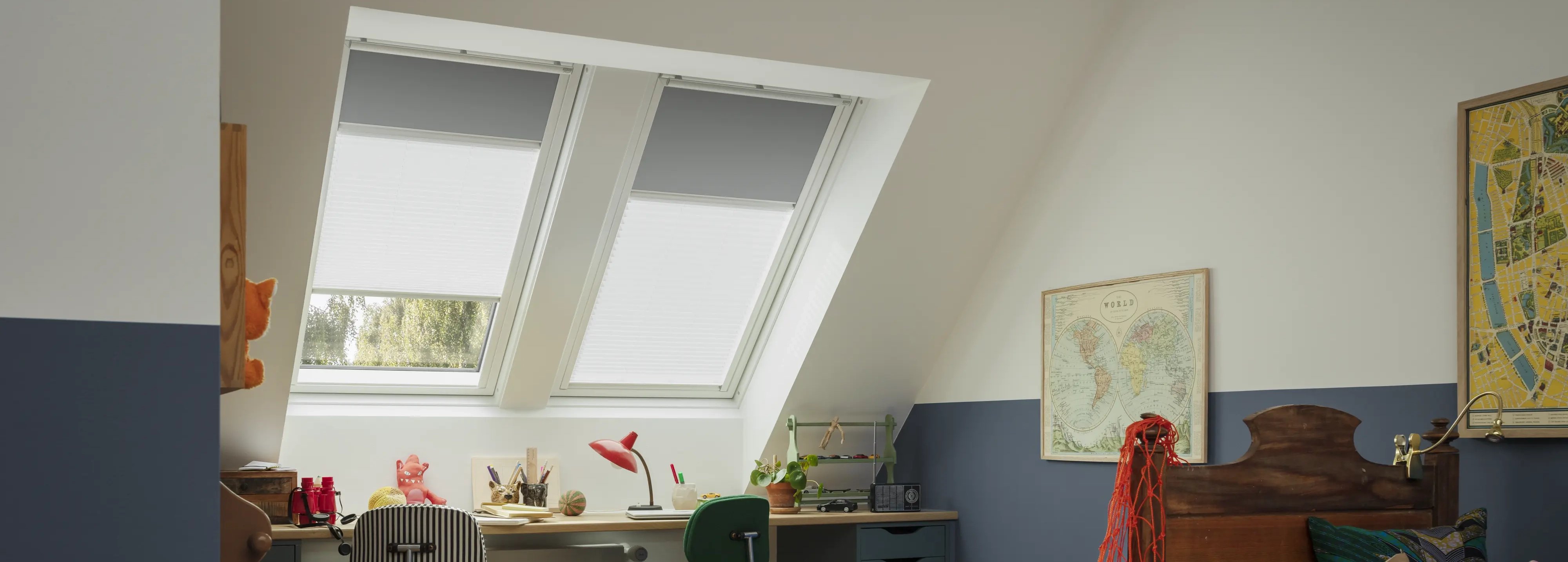 Attic kids room with sloped ceiling and VELUX roof windows, colorful decor.