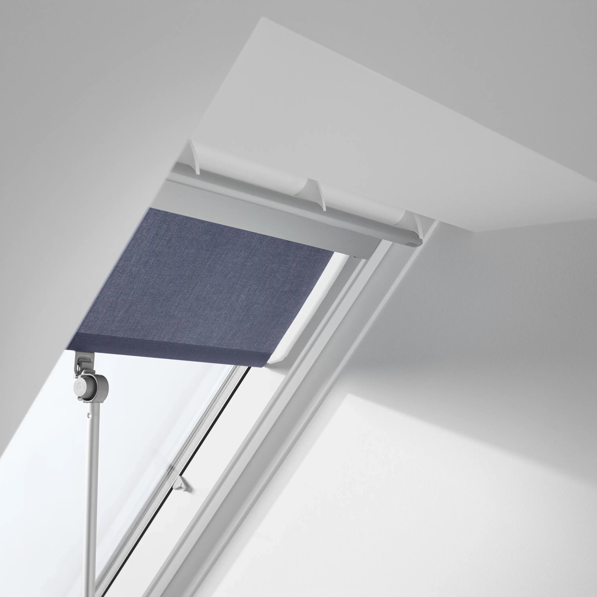 VELUX roof window with purple blind in a sloped ceiling.