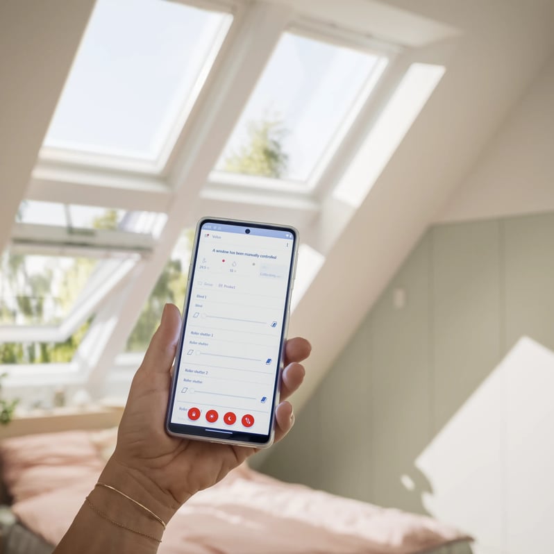 Attic bedroom with VELUX roof windows and smartphone control.