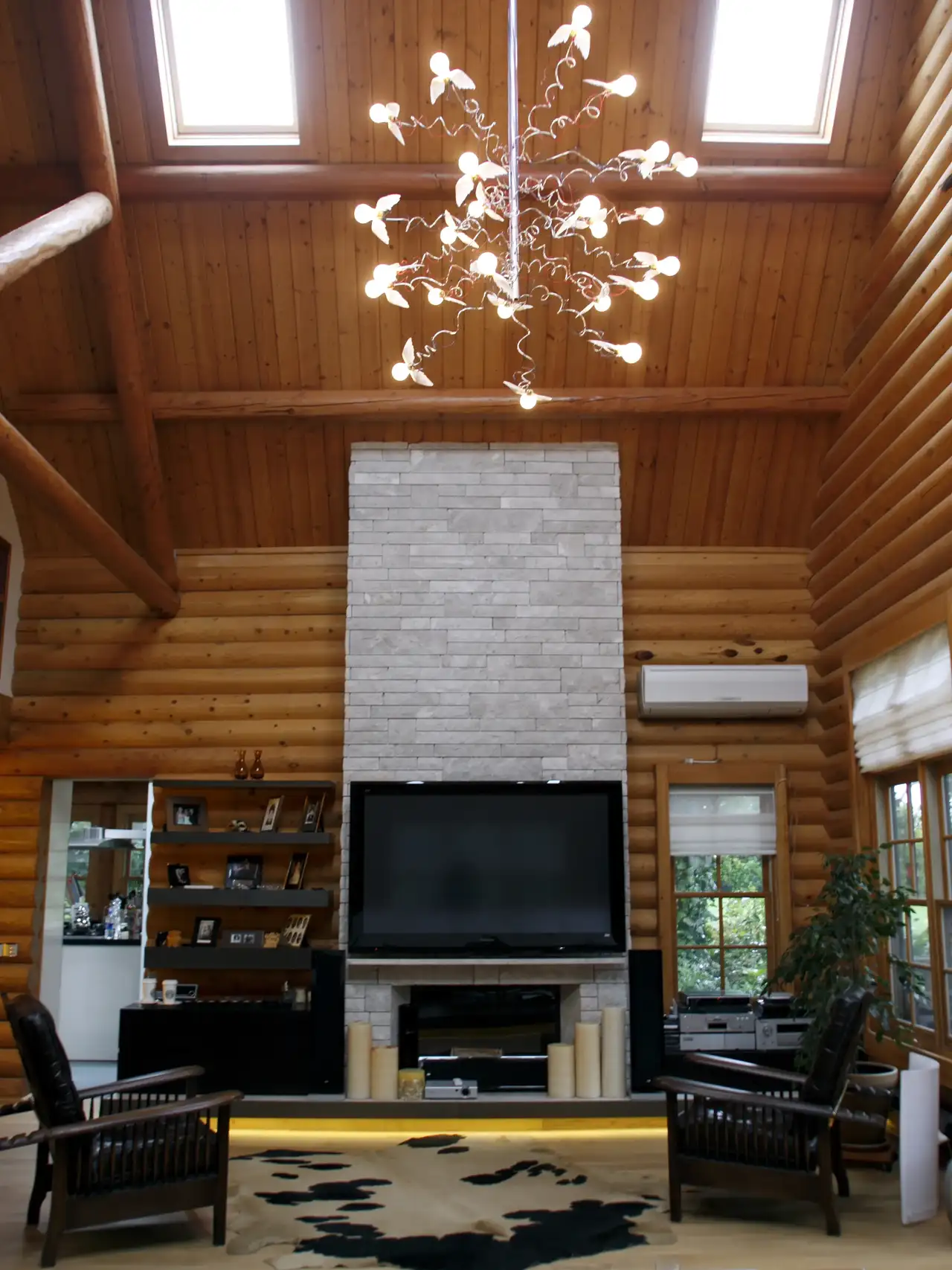 Soggiorno rustico con pareti in legno, soffitto spiovente e finestre per tetti.