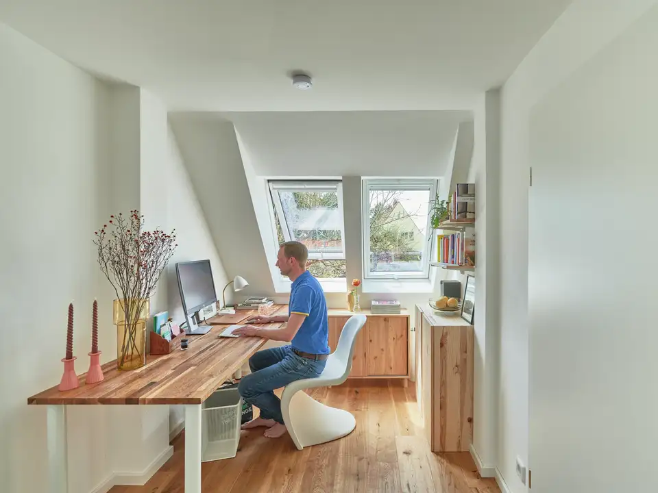 Un homme travaille à son bureau éclairé par deux fenêtres de toit VELUX 