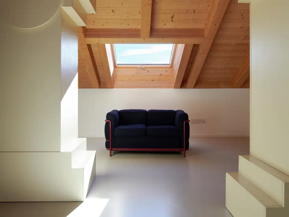 Attic room with sloped wooden ceiling and VELUX roof window, modern design.