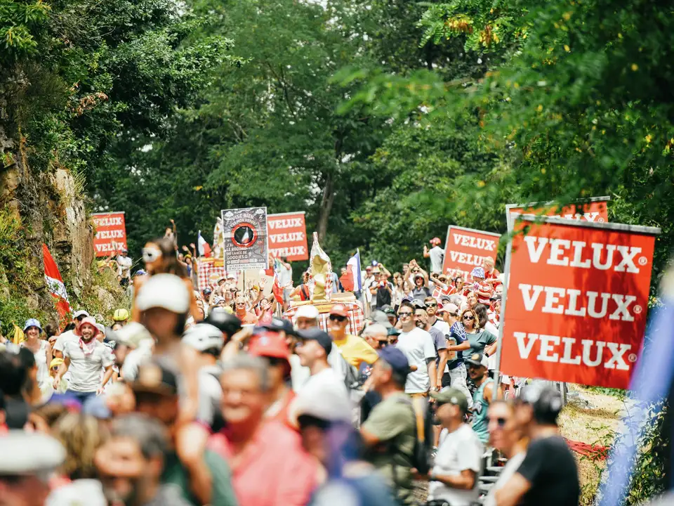 Množica na Tour de France z transparenti VELUX in bujno zeleno naravo. 