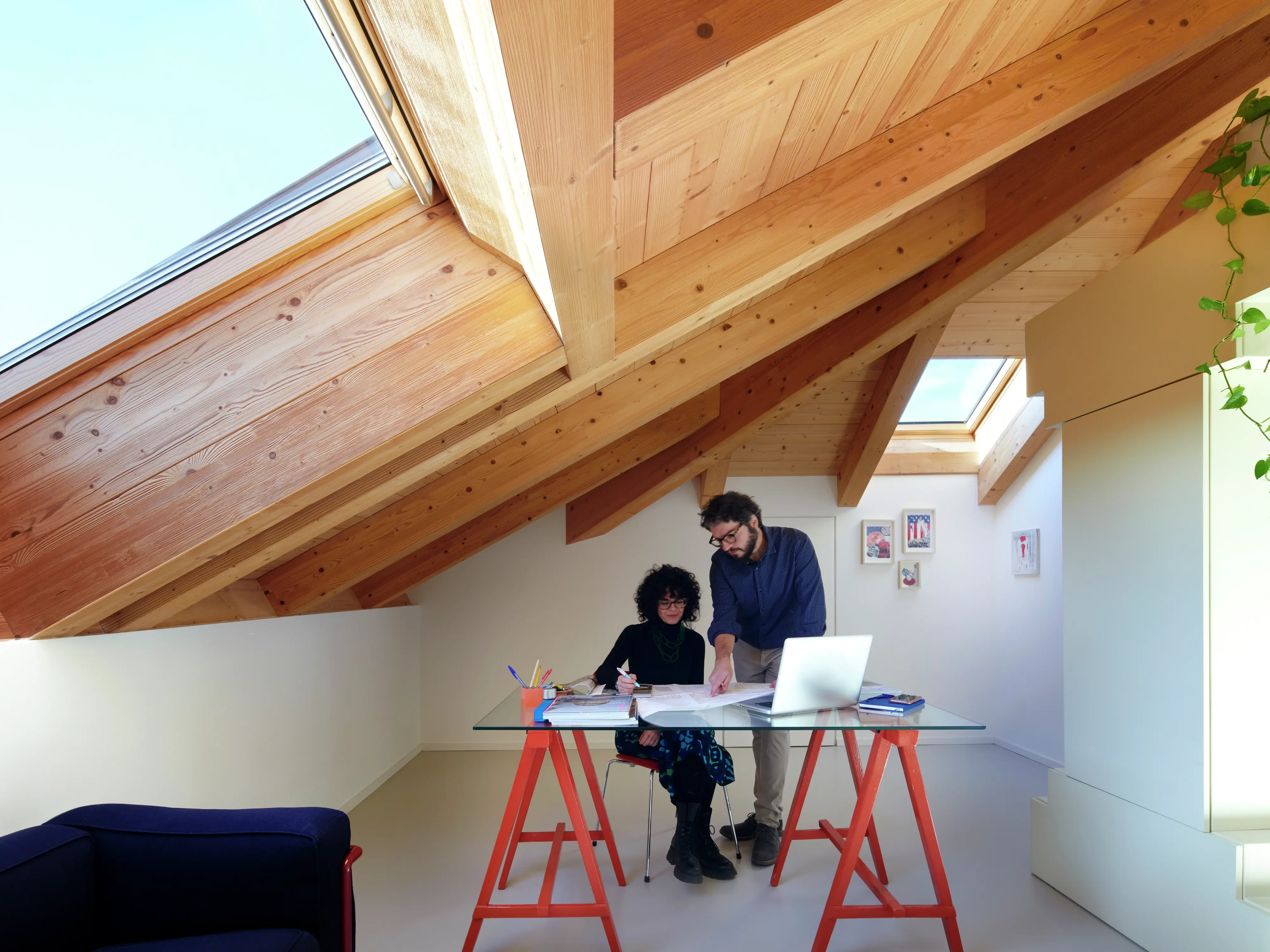 Bureau à domicile confortable dans le comble avec des fenêtres de toit VELUX et une conception intérieure en bois.