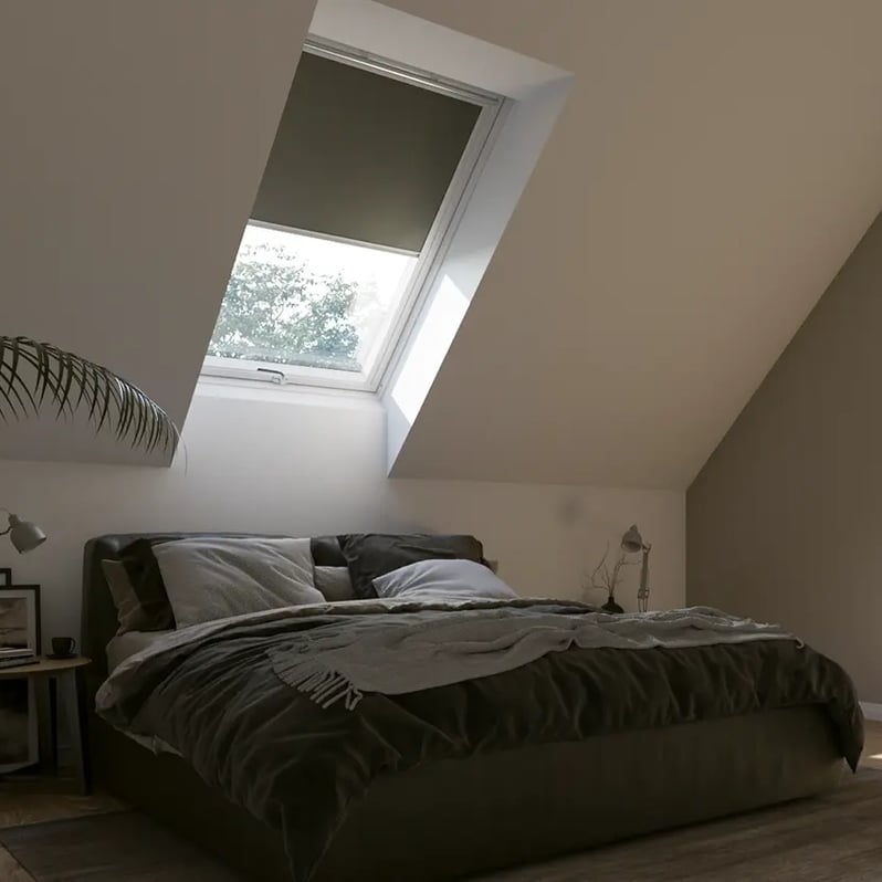 Attic bedroom with sloped ceiling and VELUX roof window, cozy and inviting.