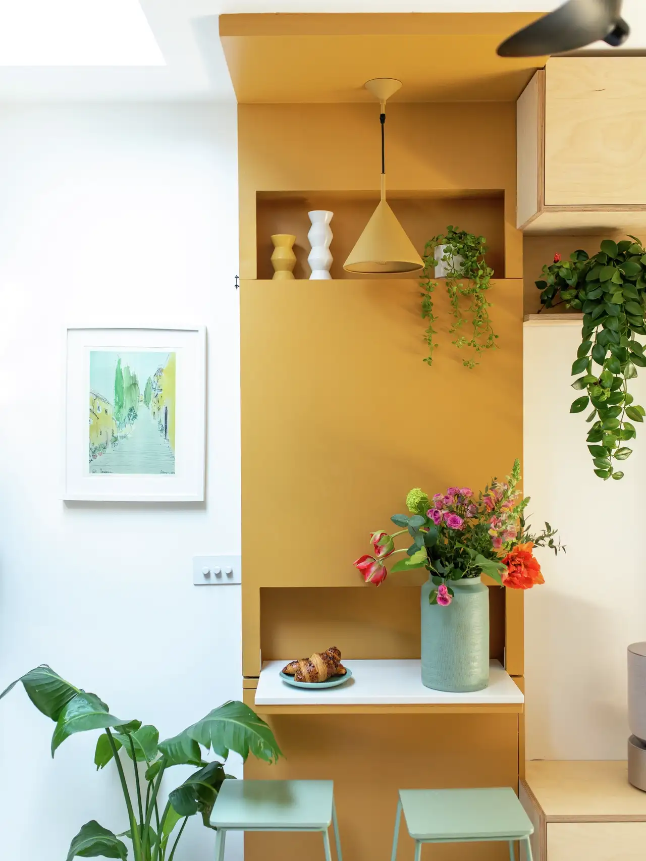 Particolare di una cucina con decorazioni e piante a terra e appoggiate su mensole.