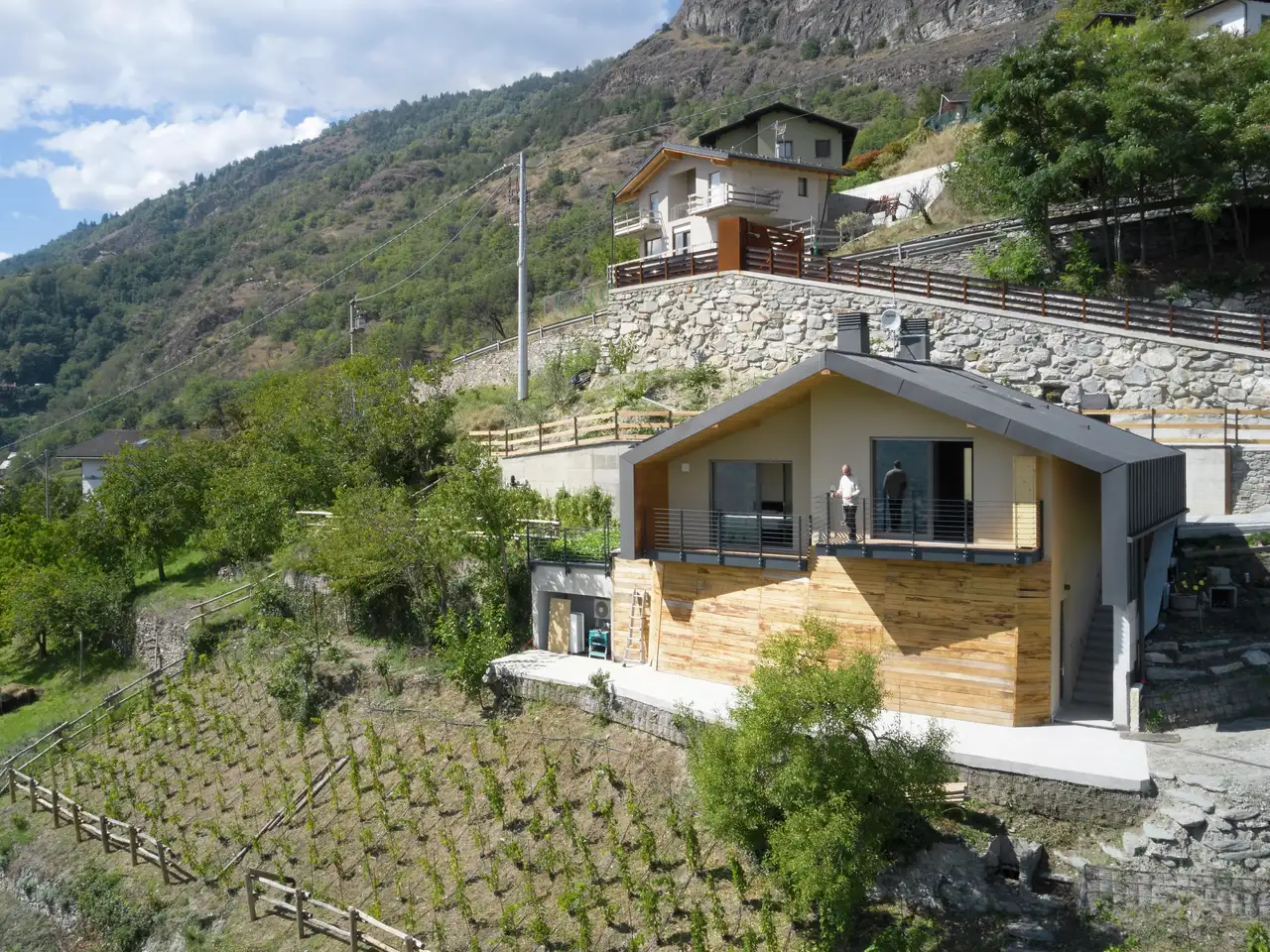 Casa moderna su un pendio con balcone e vista panoramica.
