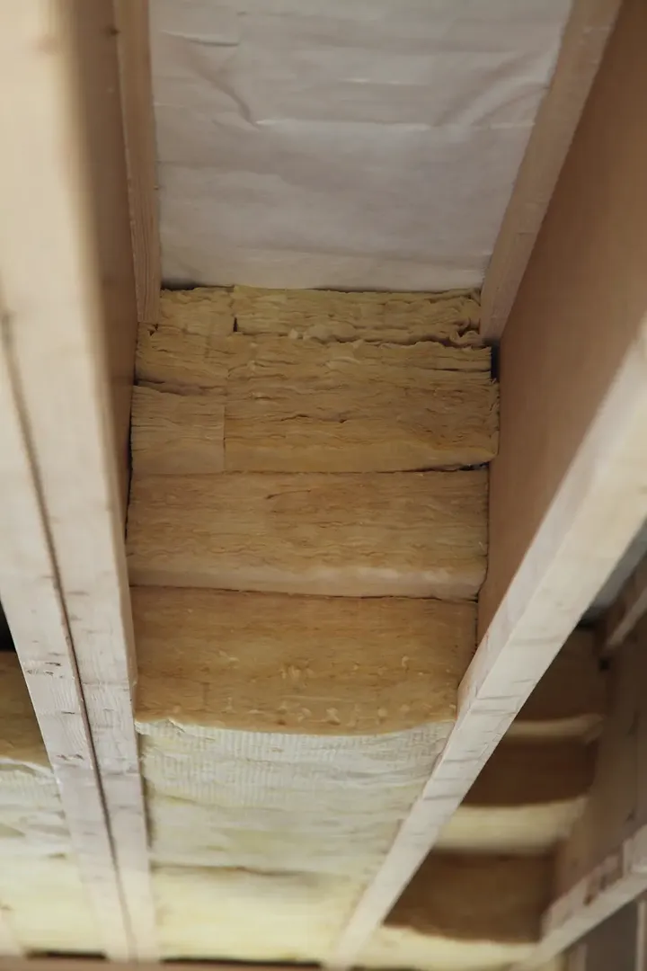 Krupni plan izolacije postavljene između krovnih greda, koji demonstrira važnost termičke efikasnosti i udobnosti u potkrovnim prostorima | VELUX.