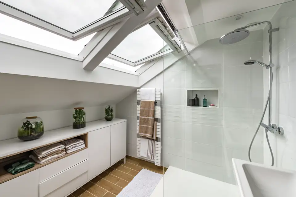 Bagno moderno con due finestre per tetti affiancate per ventilare.