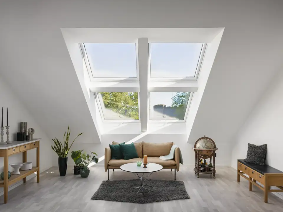 Soggiorno in mansarda con quattro grandi finestre per tetti VELUX affiancate e sovrapposte