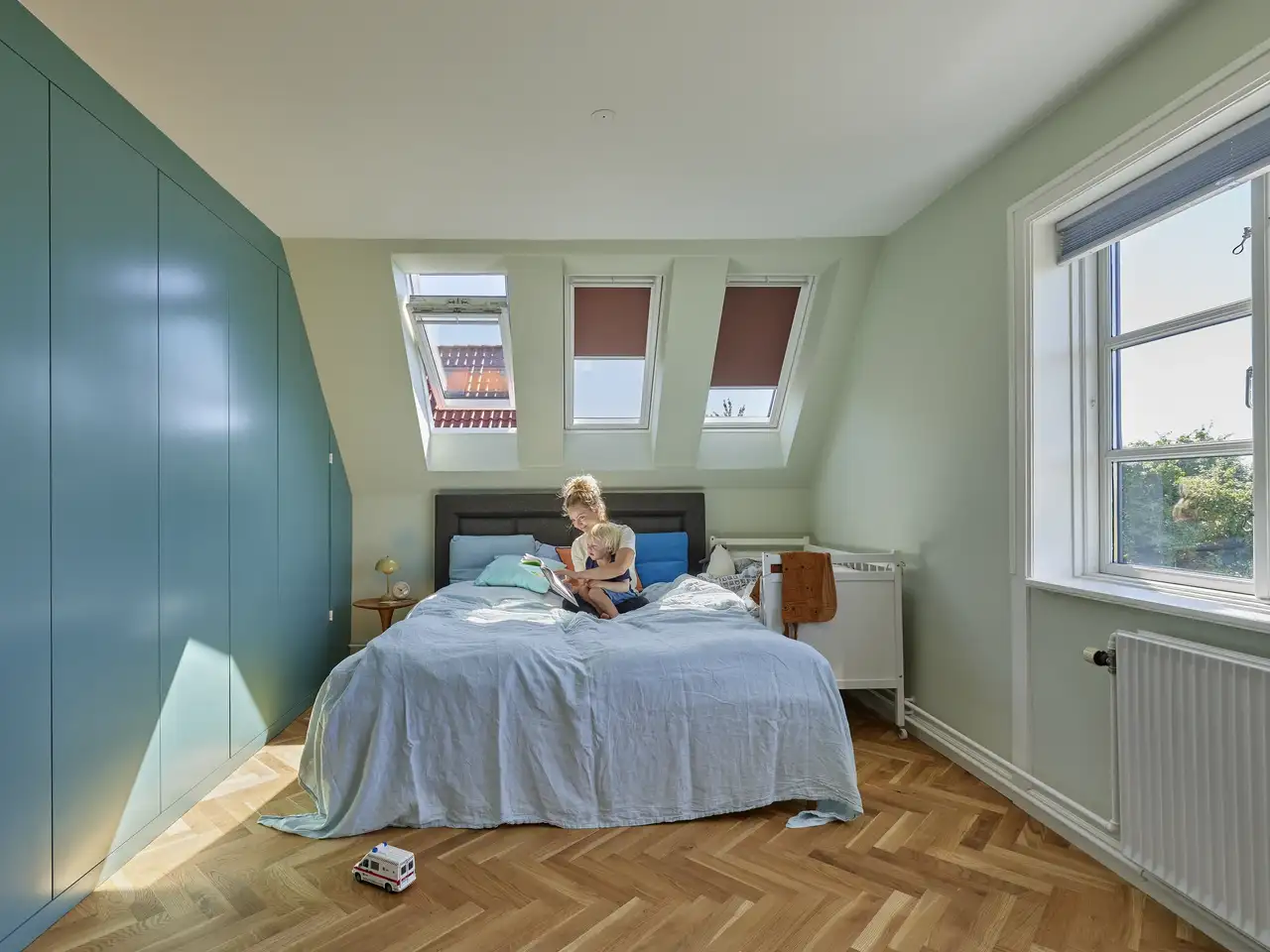 Camera da letto in mansarda accogliente e luminosa con finestre per tetti VELUX e finestre verticali
