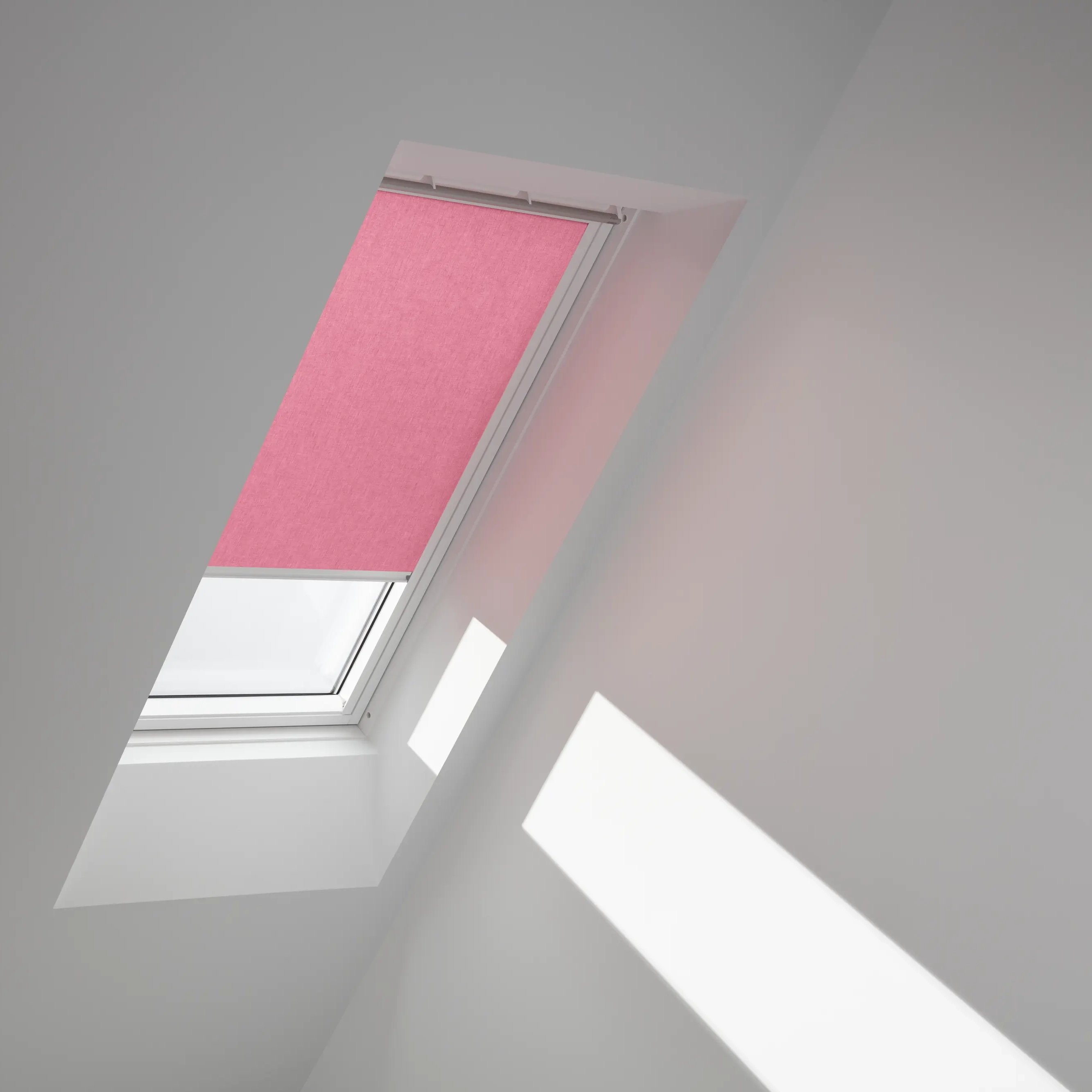 VELUX roof window with pink blind in a sloped ceiling attic room.