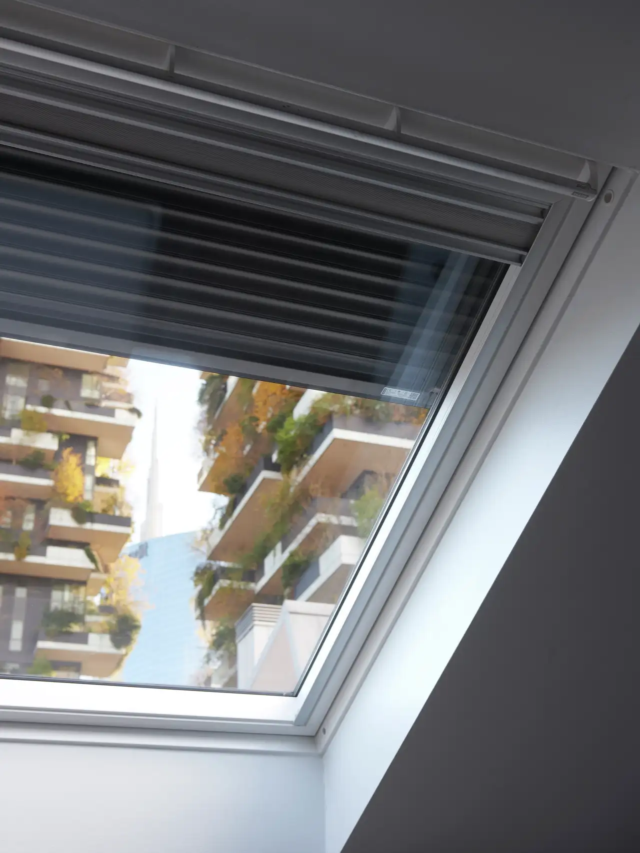 Une fenêtre de toit VELUX équipée d’un volet roulant pour isoler et assombrir la pièce. 