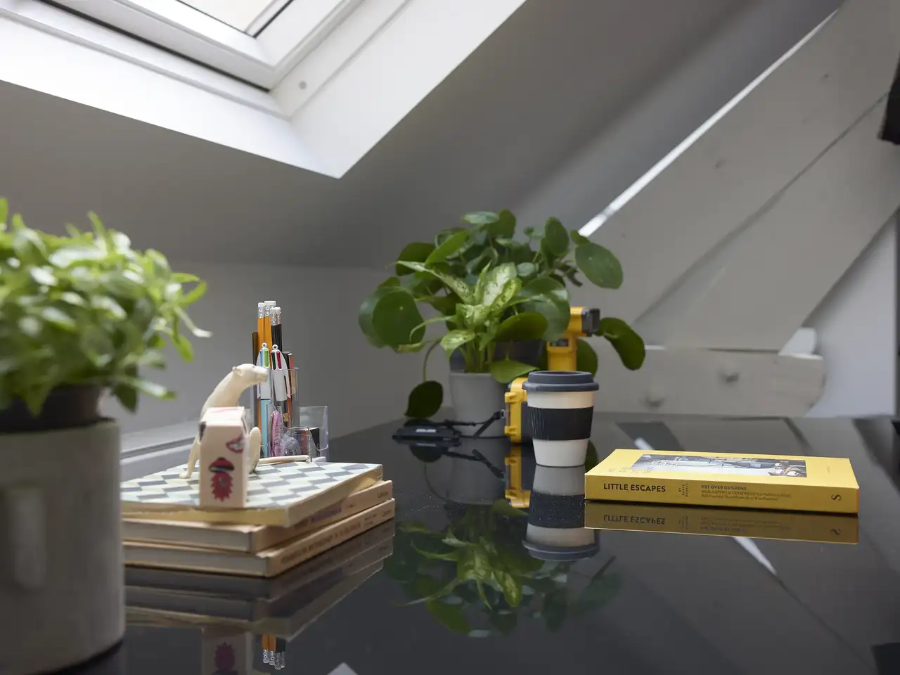 Bureau bien rangé avec surface de travail noire et brillante sous lucarne | Magazine VELUX