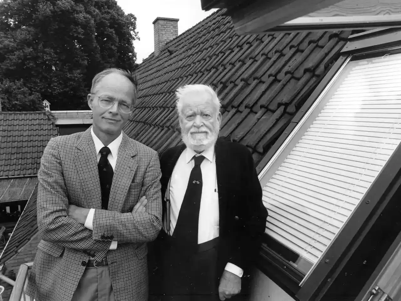 Schwarz-Weiß-Foto mit zwei Personen an einem VELUX Dachflächenfenster in einem Wohngebäude.