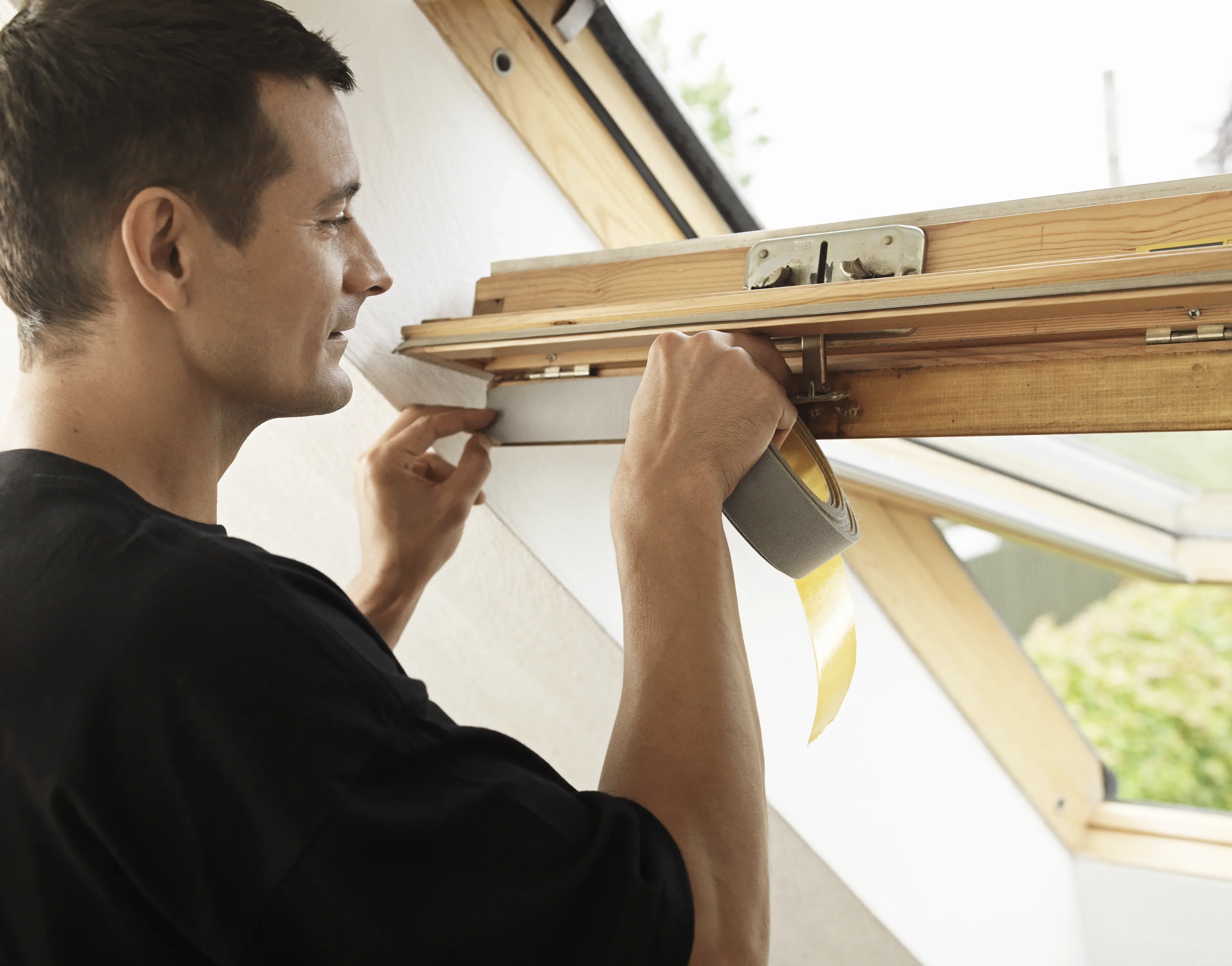 Muž montuje strešné okno VELUX