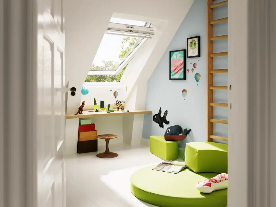 Quarto de criança no sótão com escritório instalado sob uma janela grande de telhado VELUX.