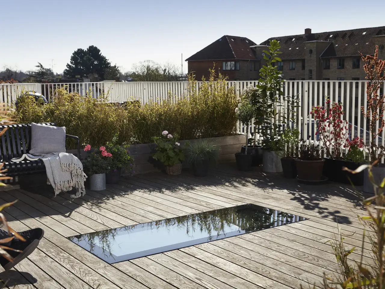 terrasse sur toit plat avec sol à lames, plantes, assises et puits de jour plat intégré au sol