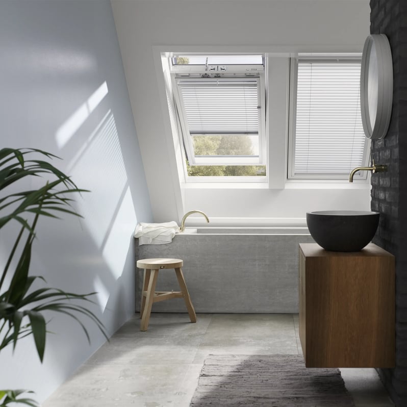 Bathroom with sloped ceiling and open VELUX roof window, modern design.