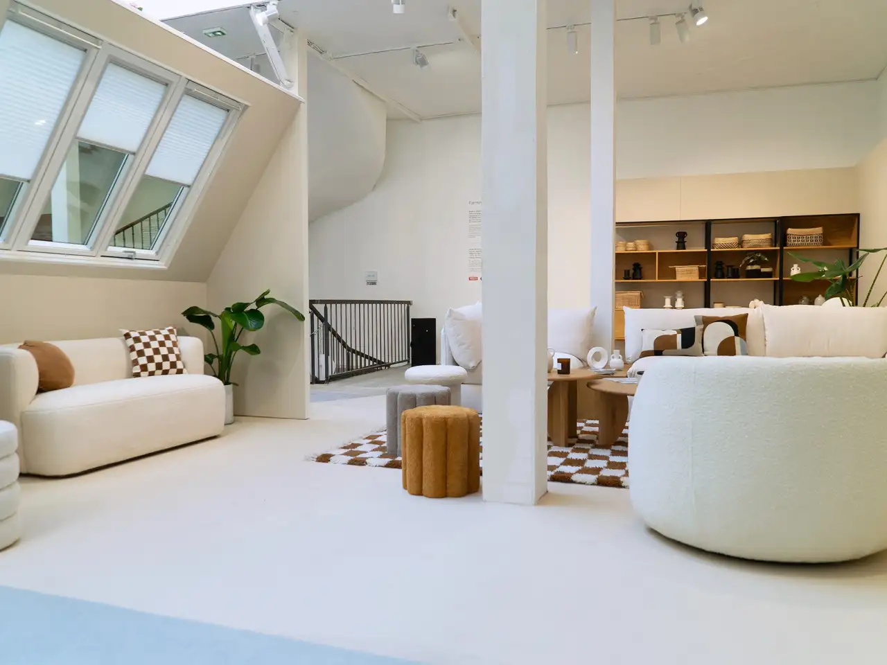 Séjour avec tapis géométrique et lampes rétro, éclairé par des fenêtres de toit VELUX équipées de volets roulants. 