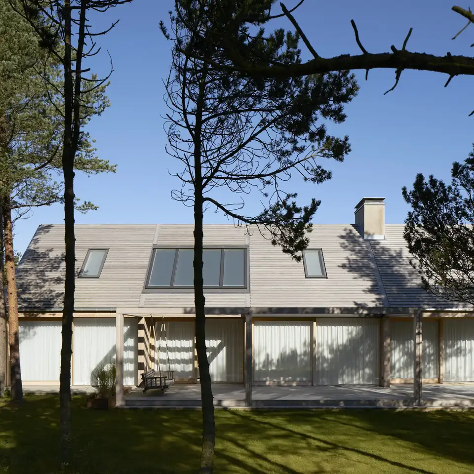 Sommerhus i skovområde med træfacade og skråtag