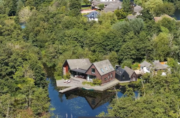 Big house in the middle of forest next to a river