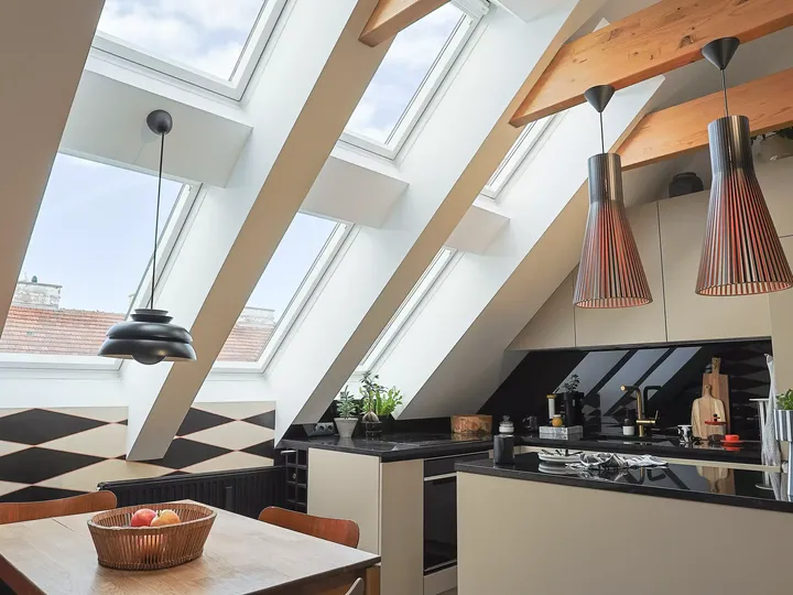 Durch große Dachfenster scheint viel Tageslicht in den stilvollen Koch- und Essbereich | VELUX Magazin