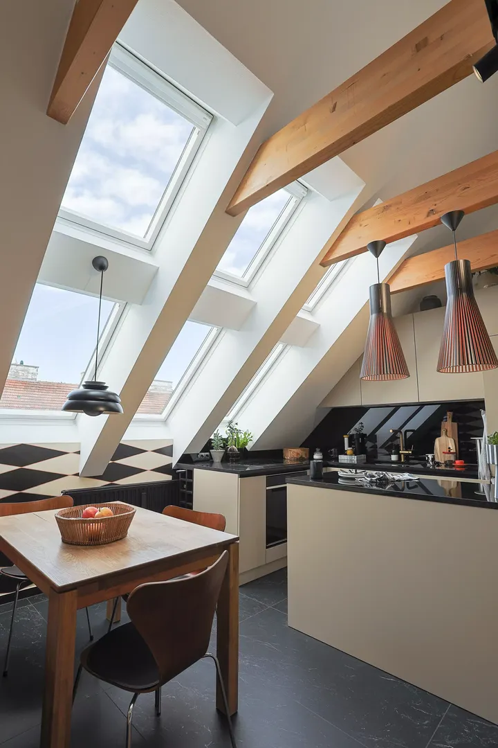 Durch große Dachfenster scheint viel Tageslicht in den stilvollen Koch- und Essbereich | VELUX Magazin