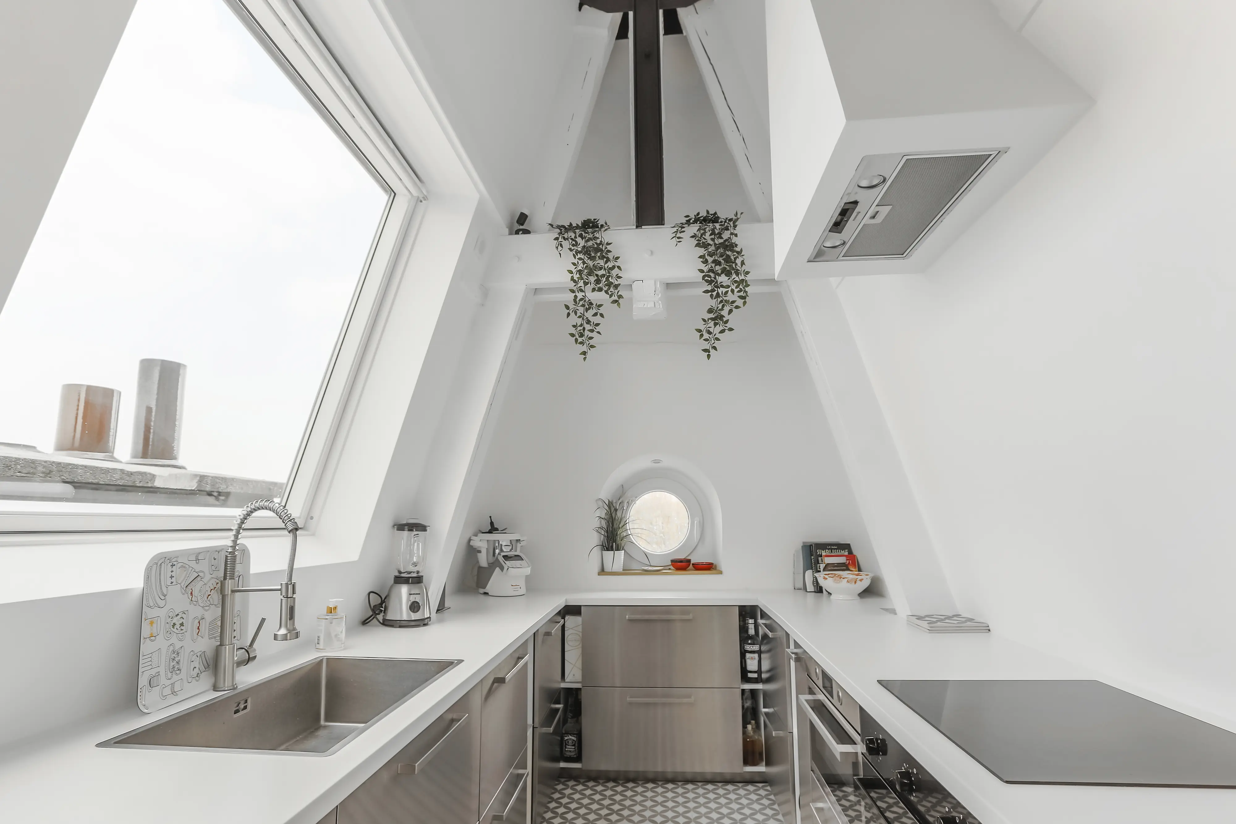Modern attic kitchen with sloped ceiling and large VELUX roof window.