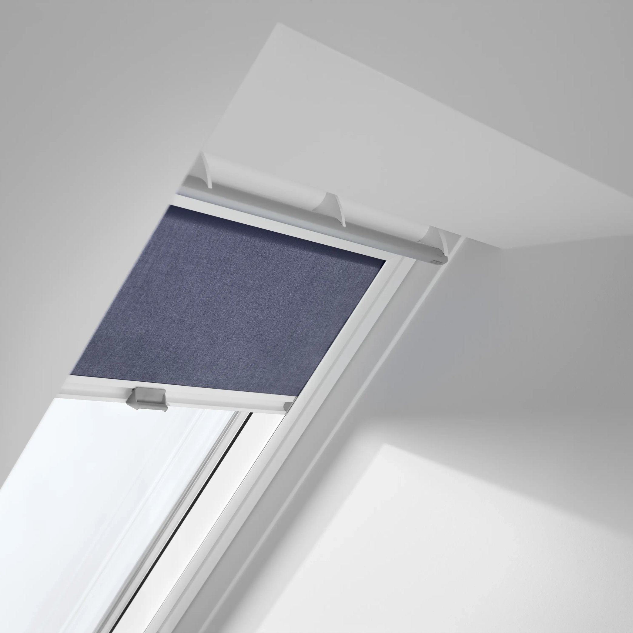 Attic with VELUX roof window and blind, sloped ceiling, modern design.