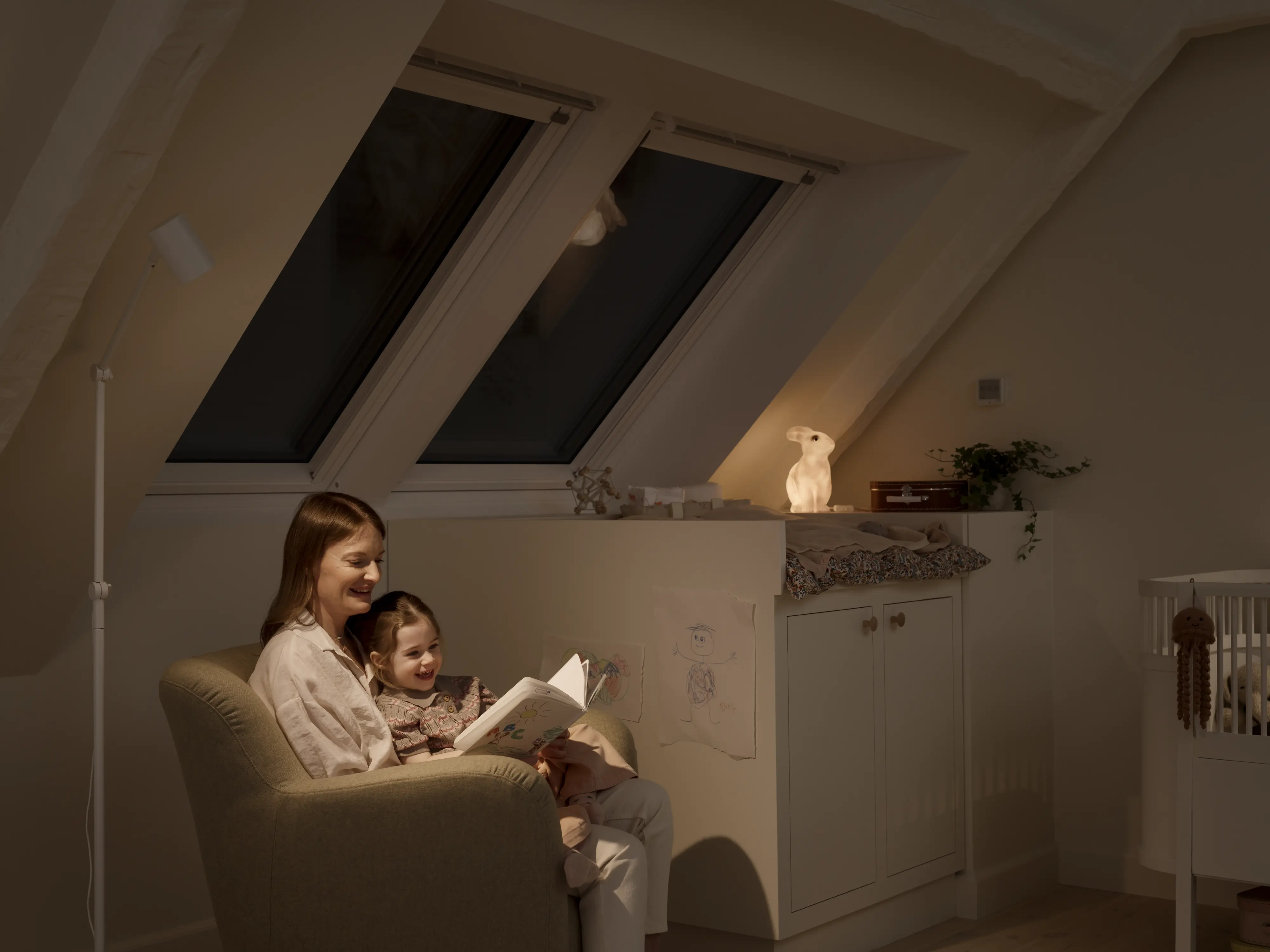 Detská izba v podkroví so šikmým stropom a strešným oknom VELUX, útulný čitateľský kútik.