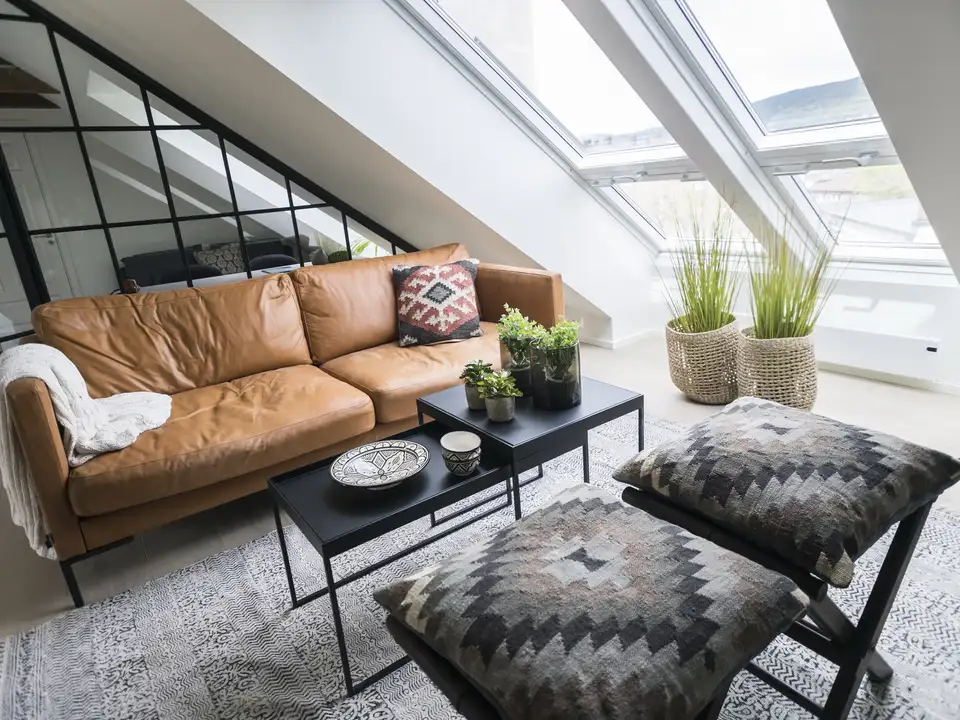 Attic living room with sloped ceiling and large VELUX roof windows.