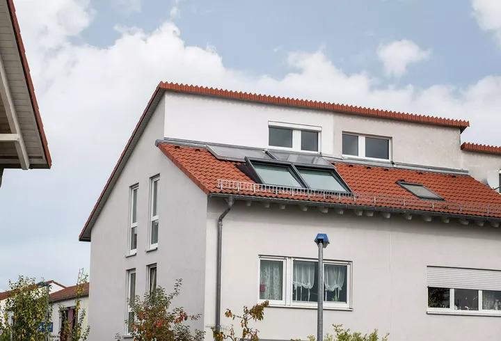 Hohes Doppelhaus mit doppeltem Pultdach mit roten Ziegeln und großen Dachfenstern | VELUX Magazin